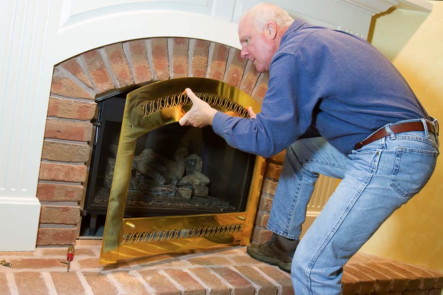 man removing gas fireplace door